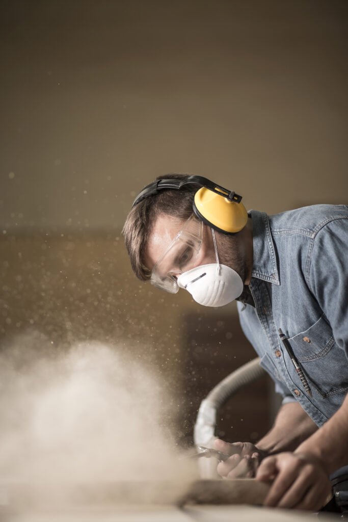 Worker with protective gear performing dust-generating work